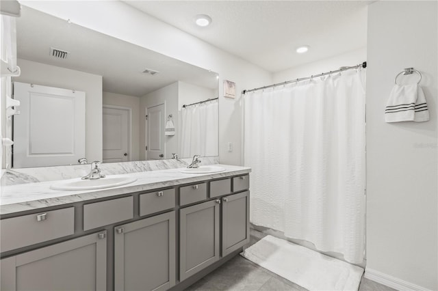 full bathroom featuring double vanity, curtained shower, a sink, and visible vents