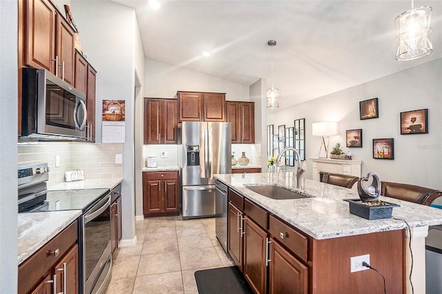 kitchen featuring pendant lighting, sink, lofted ceiling, a kitchen island with sink, and stainless steel appliances