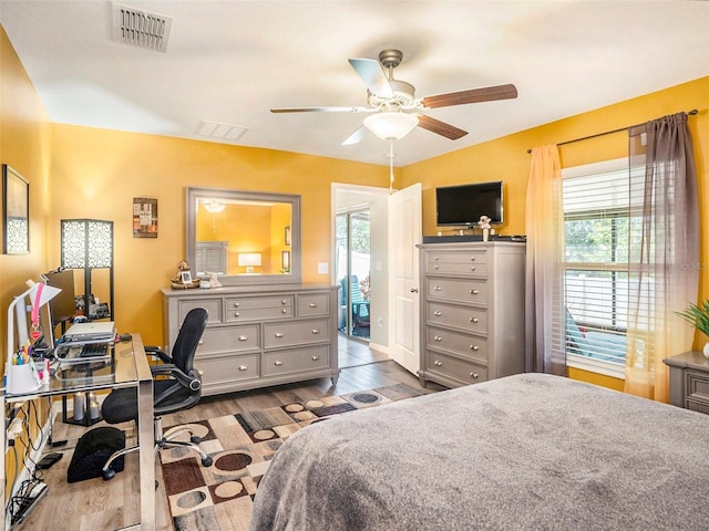 bedroom with ceiling fan, multiple windows, and light hardwood / wood-style flooring