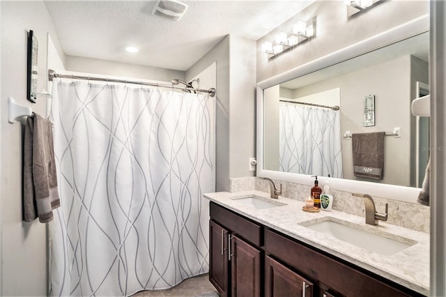 bathroom featuring vanity, a shower with shower curtain, and a textured ceiling