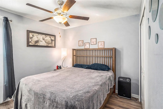 bedroom featuring dark wood-type flooring, a closet, and ceiling fan