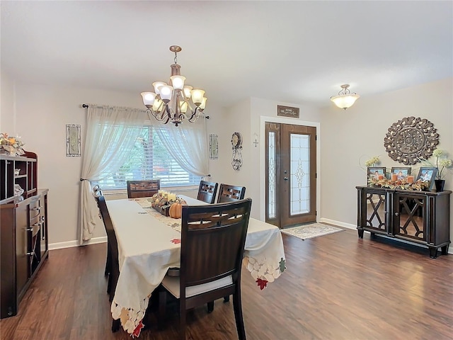 dining room with dark wood-type flooring and a chandelier