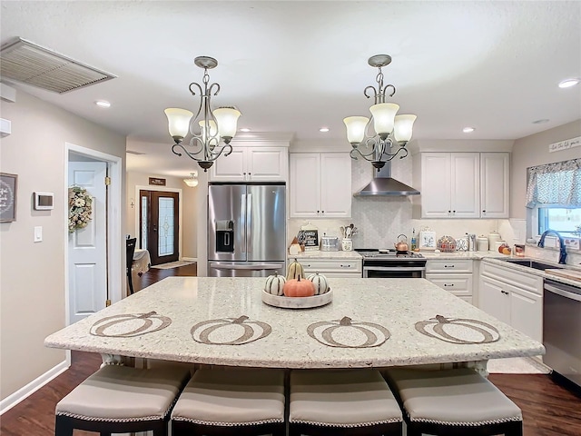 kitchen with a kitchen island, appliances with stainless steel finishes, sink, and an inviting chandelier