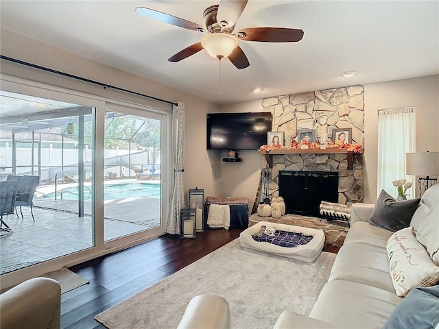 living room featuring ceiling fan, dark wood-type flooring, and a fireplace