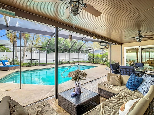 view of pool with a lanai, a patio area, outdoor lounge area, and ceiling fan