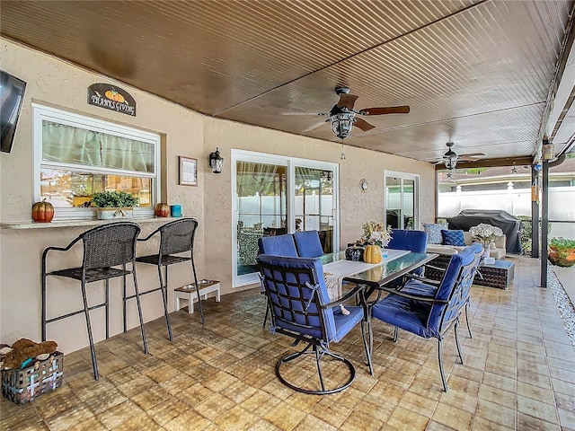 view of patio featuring ceiling fan, grilling area, outdoor lounge area, and an outdoor bar