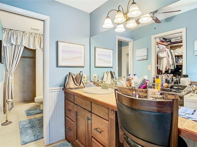 bathroom with vanity, tile patterned floors, toilet, and tiled shower