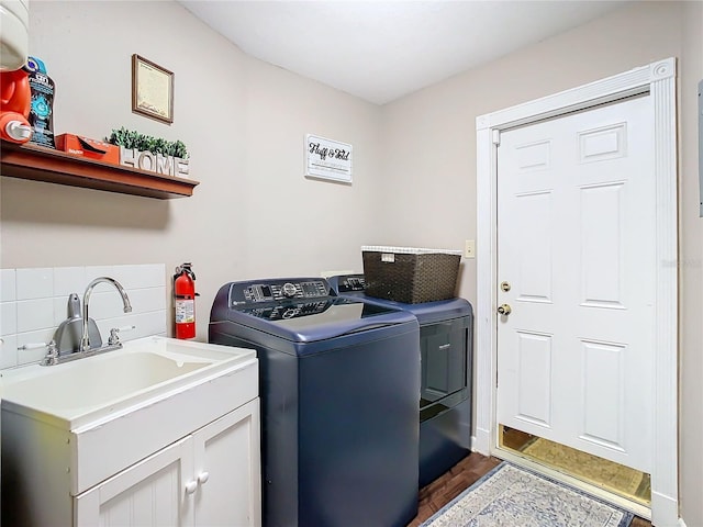 clothes washing area featuring cabinets, sink, dark hardwood / wood-style floors, and independent washer and dryer