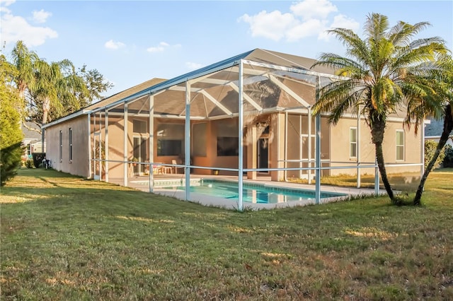 rear view of property with a yard and a lanai