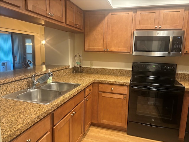 kitchen featuring sink, light hardwood / wood-style flooring, and electric range