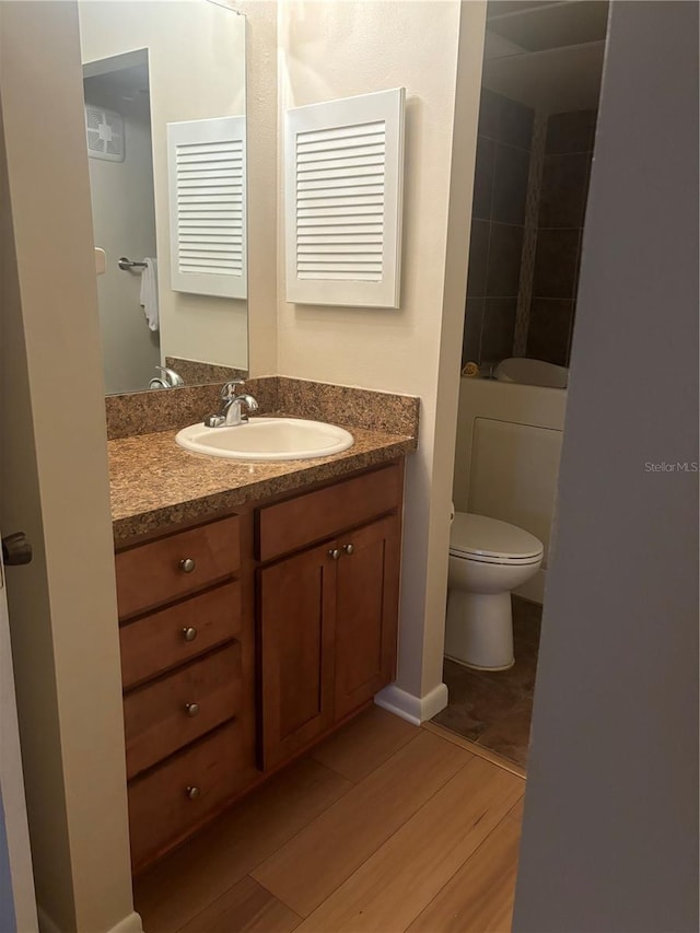 bathroom with vanity, hardwood / wood-style floors, and toilet