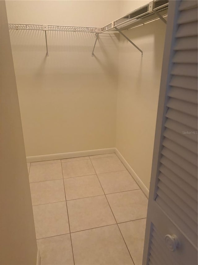 spacious closet with light tile patterned floors