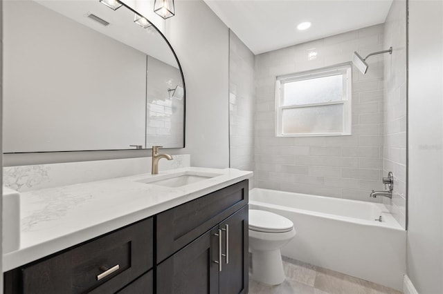 full bathroom with vanity, tiled shower / bath combo, and toilet