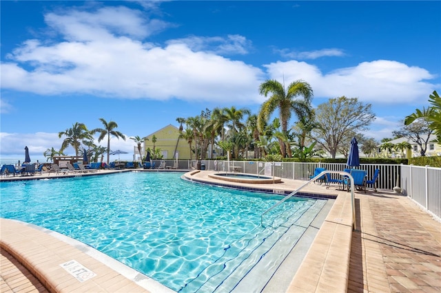 view of pool with a hot tub and a patio