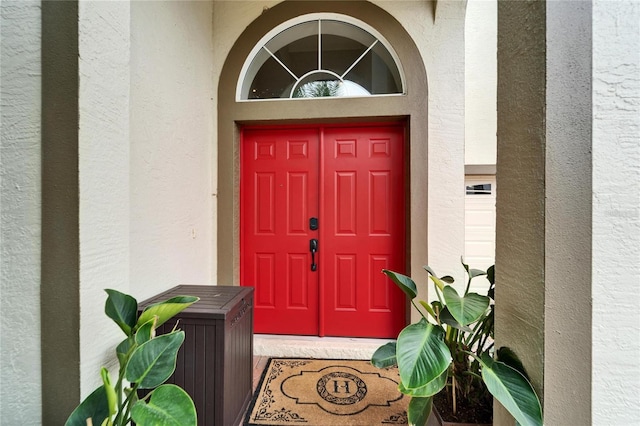 view of exterior entry featuring stucco siding