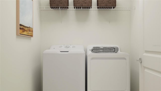 clothes washing area with washing machine and dryer