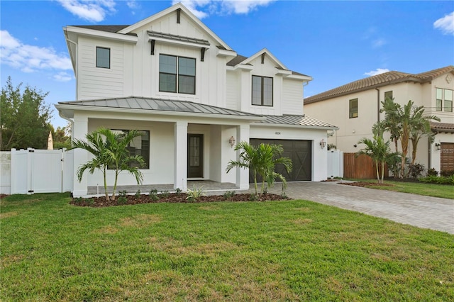 view of front of house featuring a garage, a front yard, and a porch