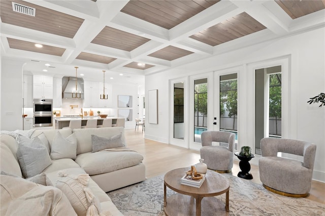 living room featuring french doors, coffered ceiling, beam ceiling, and light wood-type flooring