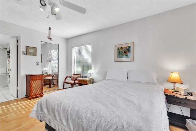 bedroom featuring ceiling fan, a closet, a textured ceiling, and light wood-type flooring