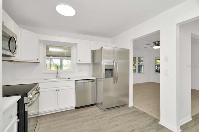 kitchen featuring stainless steel appliances, white cabinetry, and sink