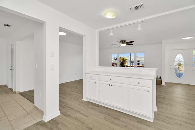 kitchen featuring white cabinetry, track lighting, light hardwood / wood-style flooring, and a wealth of natural light