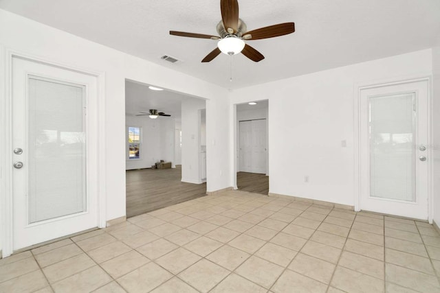 tiled spare room featuring ceiling fan