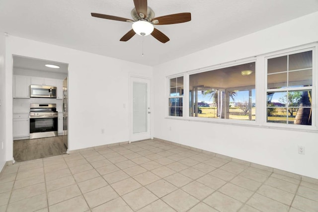 tiled empty room with ceiling fan