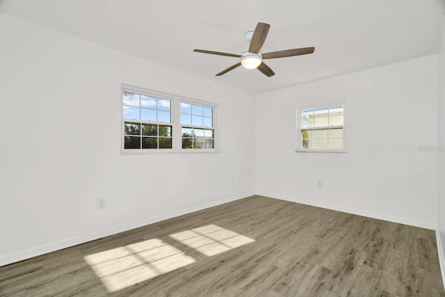 empty room with ceiling fan and dark hardwood / wood-style flooring