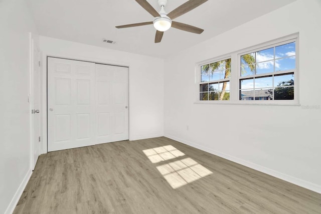 unfurnished bedroom with ceiling fan, light hardwood / wood-style floors, and a closet