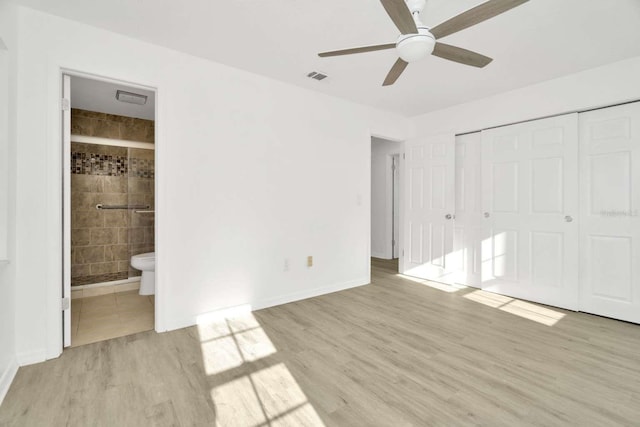 unfurnished bedroom featuring ceiling fan, connected bathroom, light hardwood / wood-style floors, and a closet