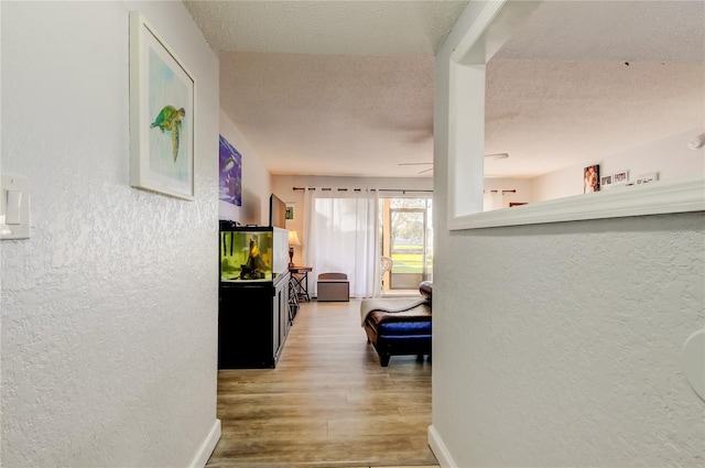 corridor featuring wood-type flooring and a textured ceiling