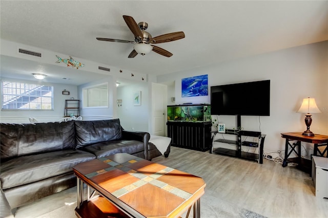 living room with light hardwood / wood-style floors and ceiling fan