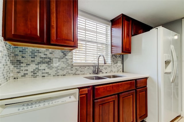 kitchen with sink, white appliances, and decorative backsplash