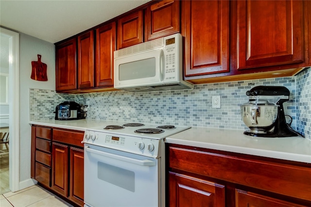 kitchen featuring light tile patterned flooring, backsplash, and white appliances