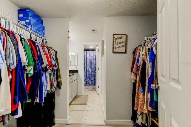 walk in closet with light tile patterned floors