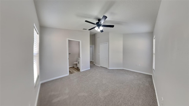 unfurnished bedroom featuring ceiling fan, a closet, ensuite bathroom, and light carpet