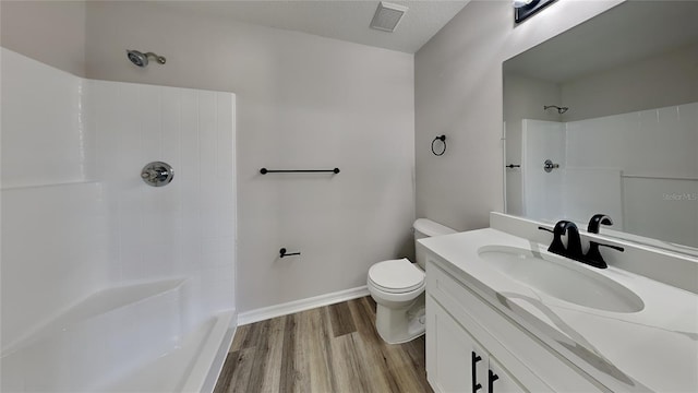 bathroom with vanity, hardwood / wood-style flooring, toilet, and walk in shower