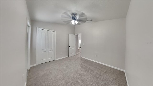 unfurnished bedroom with a closet, ceiling fan, and carpet