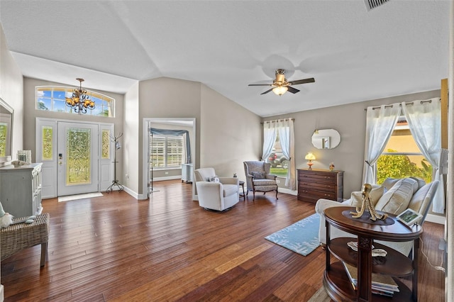 living room featuring lofted ceiling, dark wood-type flooring, ceiling fan with notable chandelier, and a textured ceiling