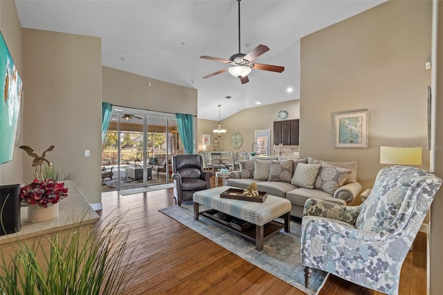 living room featuring ceiling fan with notable chandelier, wood-type flooring, and high vaulted ceiling