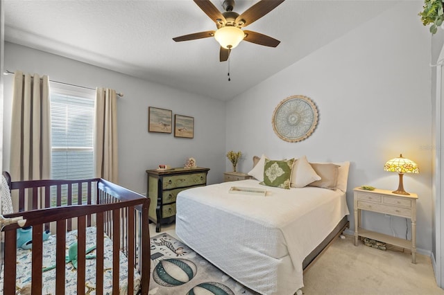 bedroom featuring vaulted ceiling, light colored carpet, and ceiling fan