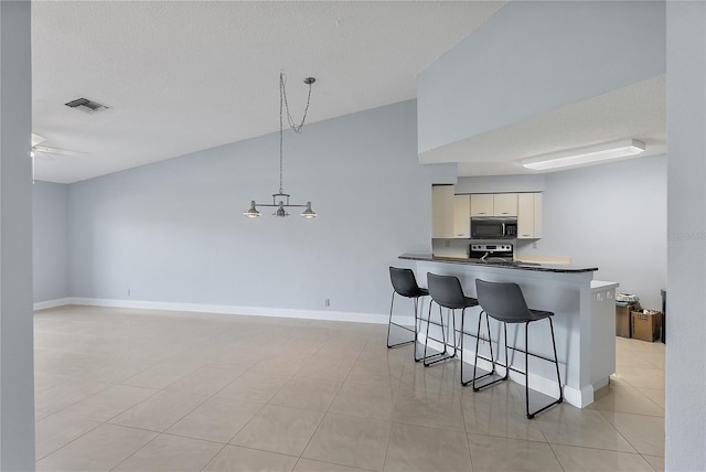 kitchen featuring pendant lighting, a kitchen breakfast bar, ceiling fan, kitchen peninsula, and stainless steel electric range