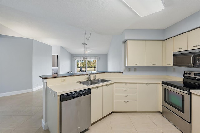 kitchen featuring sink, light tile patterned floors, appliances with stainless steel finishes, kitchen peninsula, and cream cabinetry