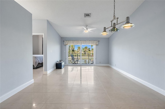 tiled spare room with ceiling fan and a textured ceiling