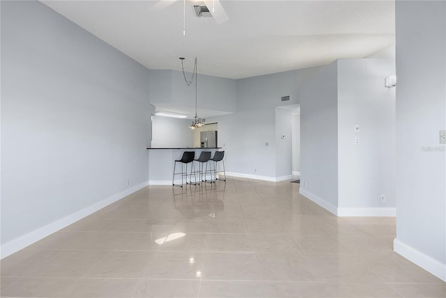 interior space featuring light tile patterned flooring, bar, and ceiling fan