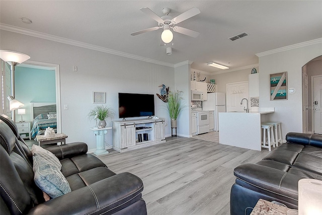 living room featuring ornamental molding, sink, ceiling fan, and light hardwood / wood-style floors