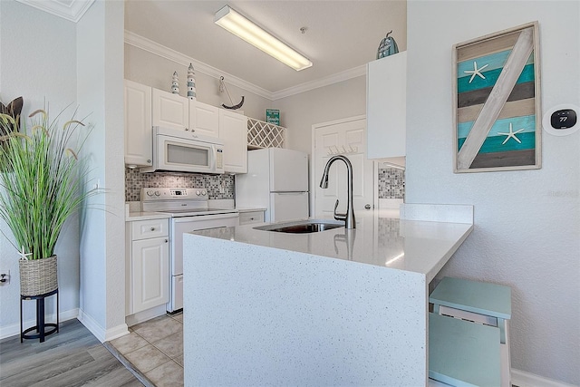 kitchen featuring sink, crown molding, white appliances, backsplash, and white cabinets