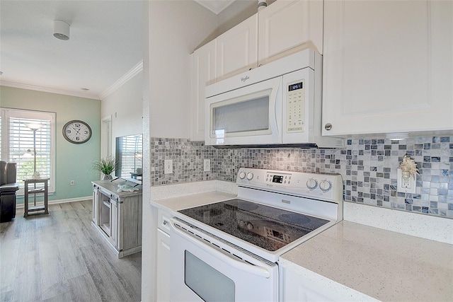 kitchen featuring white appliances, light hardwood / wood-style flooring, backsplash, ornamental molding, and white cabinets