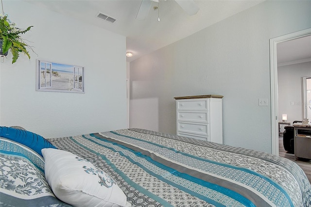 bedroom with ceiling fan, wood-type flooring, and ornamental molding