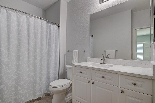 bathroom featuring vanity, toilet, and tile patterned flooring